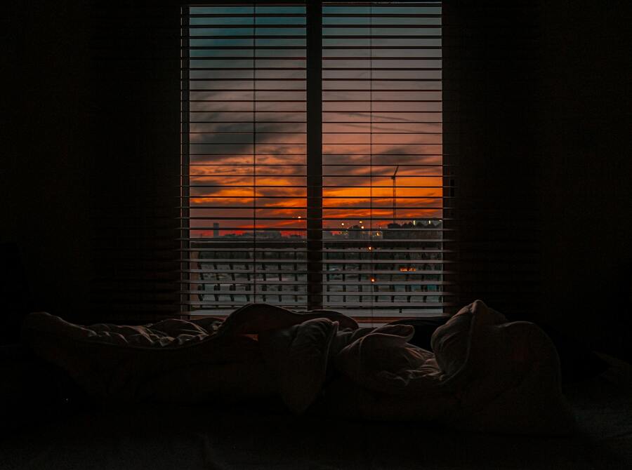 image of crumpled blanket in dark room at sunset